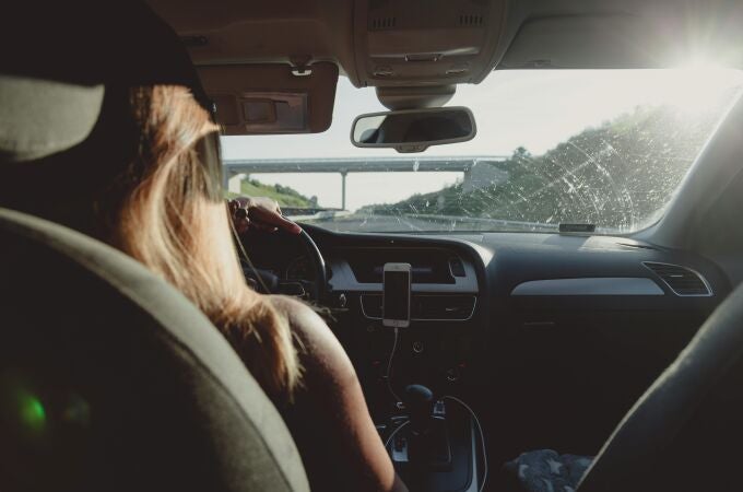 Mujer conduciendo un coche en una autopista.