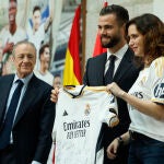 El capitán del Real Madrid, Nacho Fernández, posa con la presidenta de la Comunidad de Madrid, Isabel Díaz Ayuso y el presidente Florentino Pérez