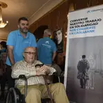 Un voluntario asiste a un usuario de la residencia de mayores Gerón de Sevilla en el cine Cervantes de Sevilla