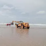 La grua remolcando el coche encallado en la arena