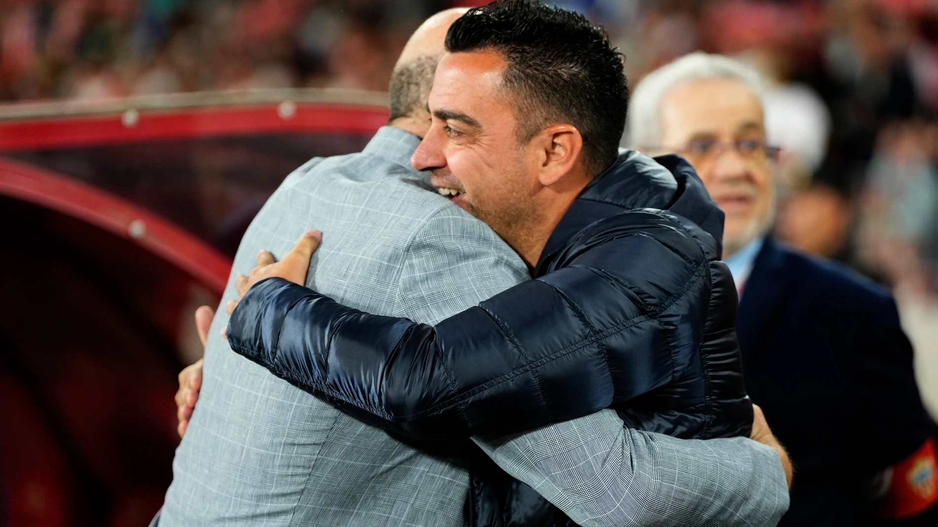 Barcelona's head coach Xavi Hernandez, right and Almeria's head coach Pepe Mel hug before a Spanish La Liga soccer match between Almeria and Barcelona at the Power Horse stadium in Almeria, Spain, Thursday, May 16, 2024. (AP Photo/Jose Breton)