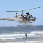 Un militar desciende de un helicóptero en la playa de San Lorenzo