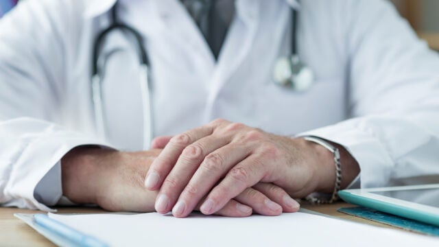Médico manos cruzadas
