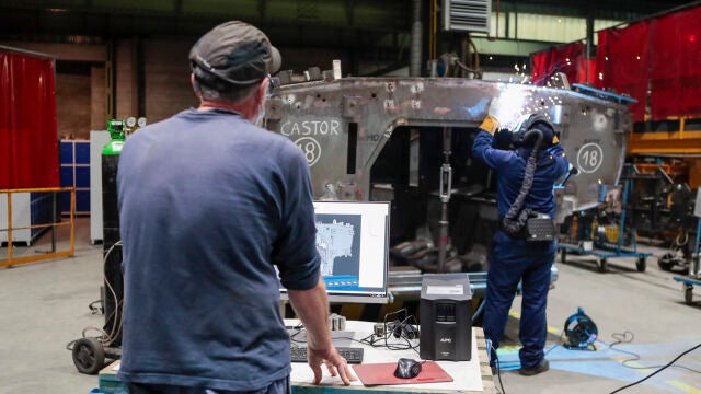 Dos operarios trabajan en la fabricación del blindado "Castor" en la fábrica de Santa Bárbara, en Trubia (Asturias)