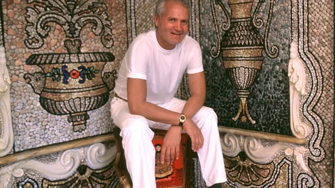 Fotografía de archivo sin fecha que muestra al diseñador italiano Gianni Versace sentado en una esquina de su casa en Miami Beach, Florida (EE.UU.)