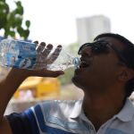 Un hombre se refresca durante una ola de calor en India