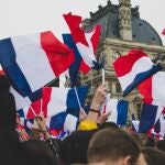 Multitud de personas ondeando la bandera nacional de Francia
