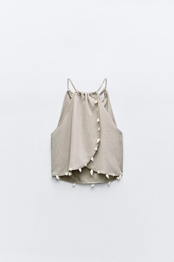 Crop top con conchas decorativas.