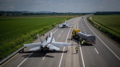 Aviones de combate F/A-18 se reabastecen de combustible durante las pruebas de la Fuerza Aérea Suiza para despegues y aterrizajes de aviones de combate en la autopista A1 entre Avenches y Payerne, Suiza occidental, el 5 de junio de 2024, con el objetivo de probar y ampliar la capacidad de descentralizar sus recursos de defensa aérea