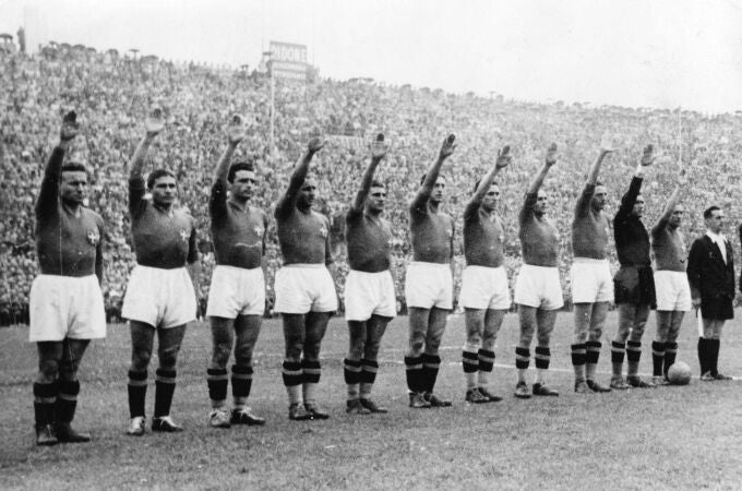 The Italian soccer team perform the fascist salute in Colombes Stadium, Paris, before the start of the World Cup final soccer match against Hungary on June 19, 1938. Earlier in the tournament that was taking place amid the drumbeat of war, the team caused consternation by wearing black shirts in a match. 