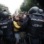 Agentes antidisturbios de la Policía Nacional forman un cordón de seguridad frente al colegio Ramón Llull de Barcelona. Policía Nacional y Guardia Civil han desplegado a sus agentes en varios colegios electorales de Barcelona para impedir el referéndum del 1-O, suspendido por el Tribunal Constitucional (TC).