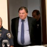 Rex Heuermann, center, charged in the Gilgo Beach serial killings on Long Island, enters the courtrrom for a hearing at Suffolk County Court in Riverhead, N.Y.