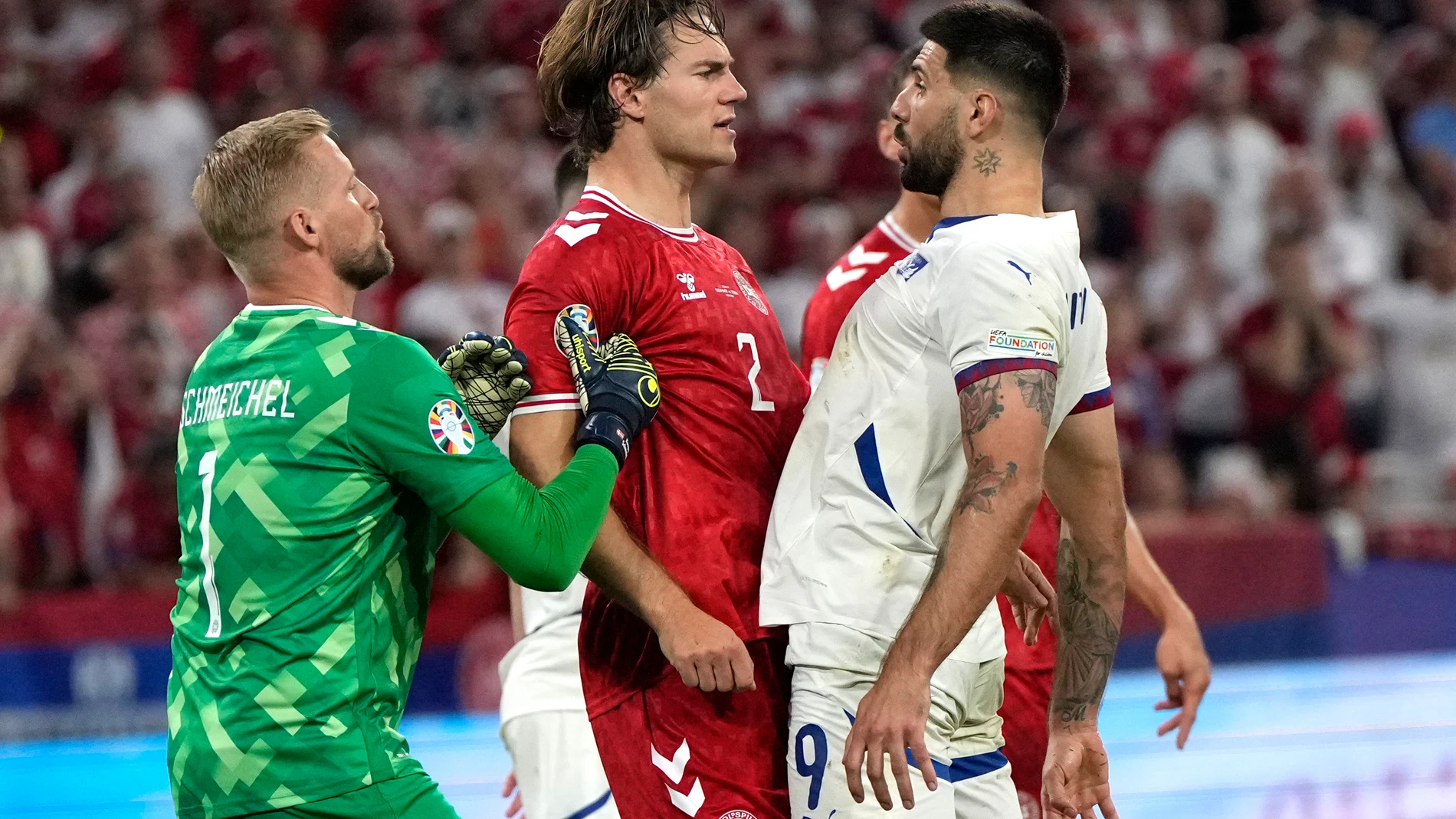 Serbia's Aleksandar Mitrovic, right, argues with Denmark's Joachim Andersen, center left, during a Group C match between Denmark and Serbia at the Euro 2024 soccer tournament in Munich, Germany, Tuesday, June 25, 2024. (AP Photo/Matthias Schrader)