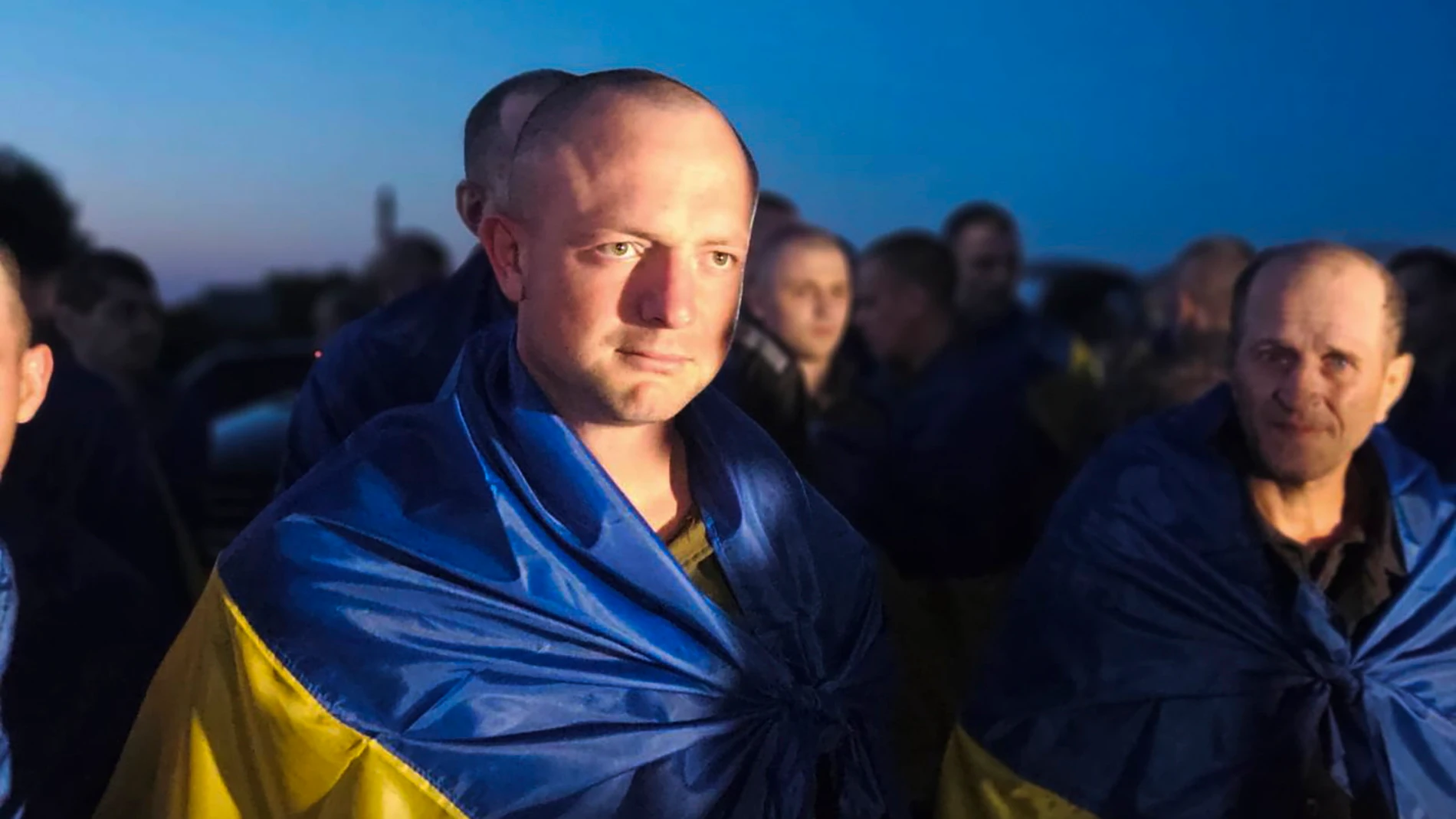 Undisclosed (Ukraine), 25/06/2024.- A handout photo made available by the Ukrainian Presidential Press Service shows Ukrainian prisoners of war covered in national flags as they arrive on Ukraine-controlled territory, at an undiscloed location in Ukraine, 25 June 2024. Ninety Ukrainians returned home from Russian captivity, according to President Zelensky. Russian troops entered Ukrainian territory on 24 February 2022, starting a conflict that has provoked destruction and a humanitarian crisi...