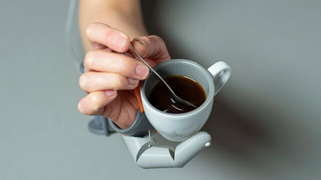 Sostener la taza de café y revolver el azúcar, todo con una mano gracias al tercer pulgar.