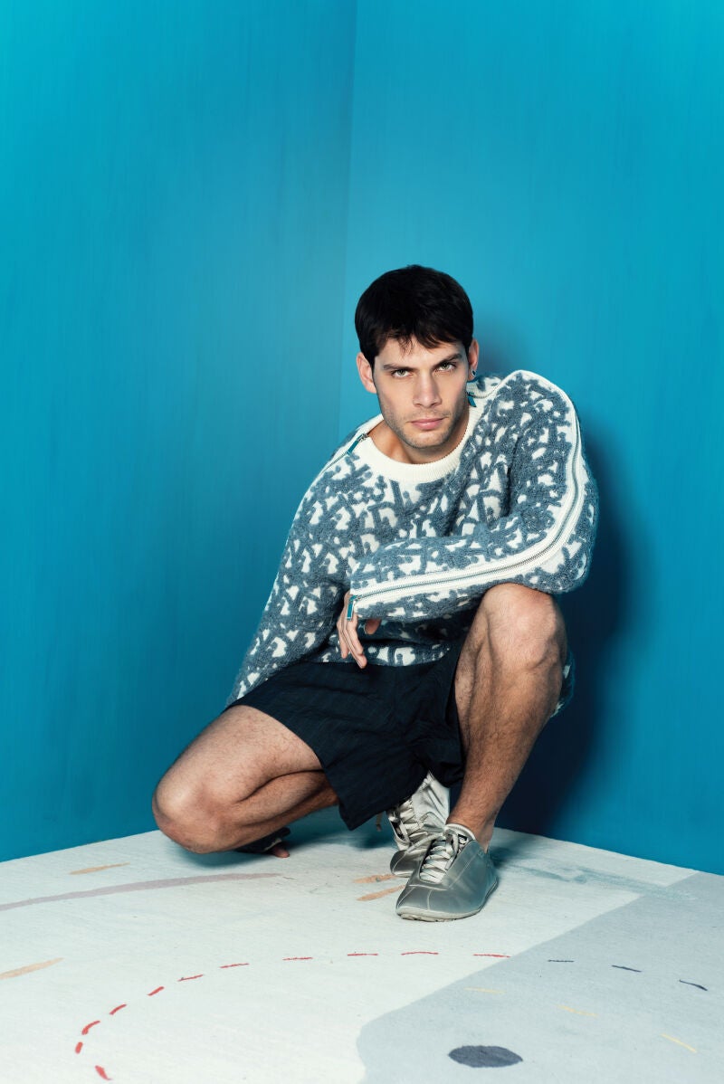 Pol Hermoso vistiendo jersey, pantalón corto, mocasines y pendientes de Dior Men