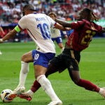 Kylian Mbappé y Jeremy Doku disputan la pelota.