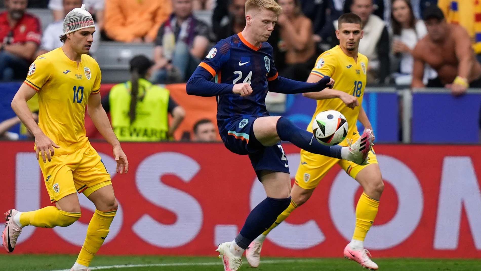 Jerdy Schouten of the Netherlands, center, tries control the ball followed by Romania's Ianis Hagi, left, during a round of sixteen match between Romania and the Netherlands at the Euro 2024 soccer tournament in Munich, Germany, Tuesday, July 2, 2024. (AP Photo/Matthias Schrader)