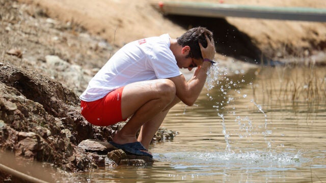 Un hombre se refresca en un río de la comunidad