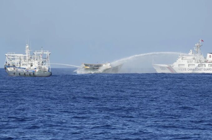 Un buque filipino, en el centro, es alcanzado por cañones de agua de dos barcos guardacostas chinos cuando intentaba llegar al disputado atolón Second Thomas, en el Mar de China Meridional