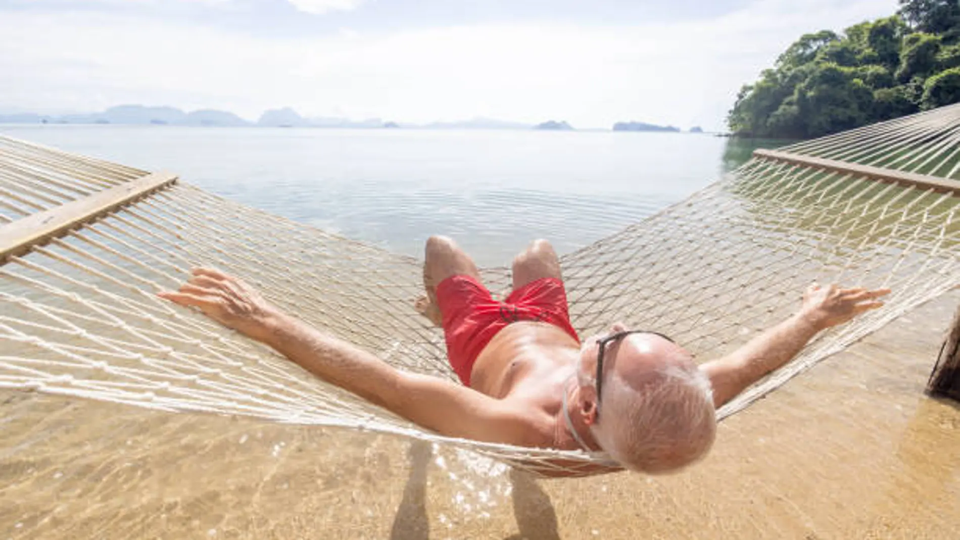 Un hombre toma el sol frente a la playa