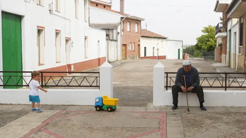 Un niño juega con una persona mayor en la localidad vallisoletana de Mayorga