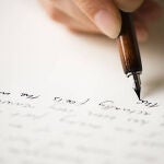 Una persona escribiendo sobre una hoja