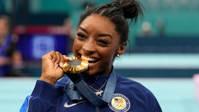 Simone Biles muerde la medalla de oro que consiguió en concurso completo
