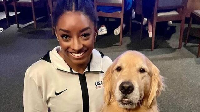 La gimnasta Simone Biles con Beacon, Golden Retriever de cuatro años, que acompaña al equipo de gimnasia artística de Estados Unidos como perro de terapia.