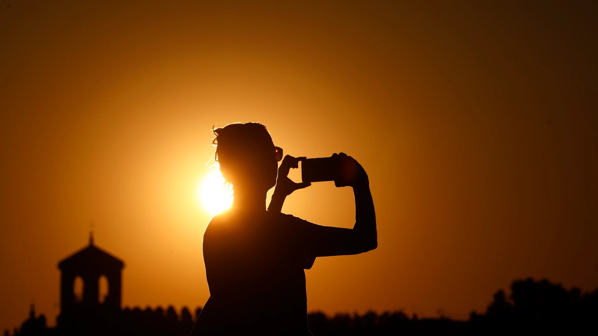GRAF5962. CÓRDOBA, 03/08/2024.- Una persona fotografía el atardecer en una jornada de altas temperaturas de 40 grados, este sabado en Códoba. EFE/Salas