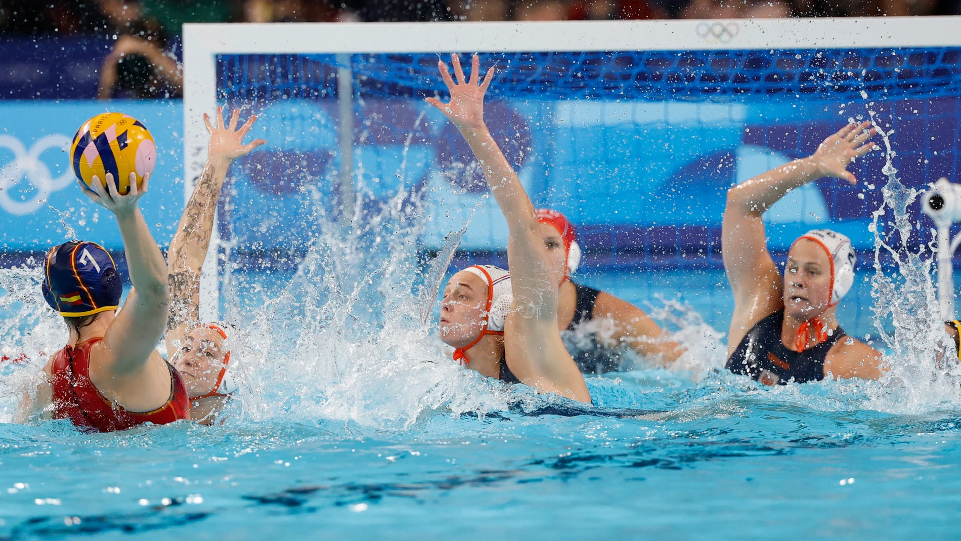 NANTERRE, 08/08/2024.- La waterpolista española Elena Ruiz (i) en acción ante la defensa de Países Bajos durante la semifinal femenina de Waterpolo, entre Países Bajos y España, parte de los Juegos Olímpicos de París 2024 este jueves en Nanterre. EFE/ Juanjo Martín