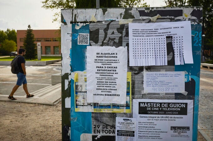 Carteles con ofertas de alquiler de habitaciones en Madrid.