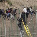 Fotografía de archivo tomada el 13/8/2014, de los inmigrantes encaramados a la valla de Melilla. Este martes se cumplen 10 años de un salto a la valla de Melilla que hizo historia. Y no solo por ser el más largo hasta la fecha (16 horas), sino, sobre todo, porque llegó a ser juzgado en Europa y a punto estuvo de cambiar las cosas en las siempre polémicas devoluciones cuya legalidad ponen en duda no pocas voces. 