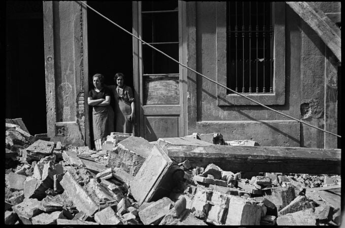 Fotografía de dos mujeres que observan los efectos de un bombardeo en el barrio de la Barceloneta de Barcelona, en 1937