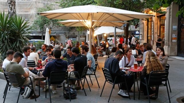 Una terraza de una cafetería llena de gente