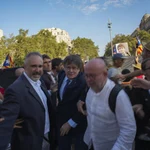 Catalan independence leader and former President Carles Puigdemont, center, arrives to address supporters and to attend the investiture debate near the Catalan parliament in Barcelona, Spain, Thursday Aug. 8, 2024.