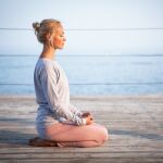 Mujer meditando en la costa