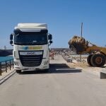 Operarios municipales retirando con camiones las algas acumuladas en las playas de Tarifa