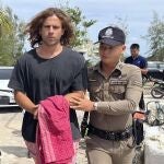 A Thai police officer escorts Spanish Daniel Sancho Bronchalo on suspicion of murdering and dismembering a Colombian surgeon from Koh Phagnan island to Koh Samui Island court