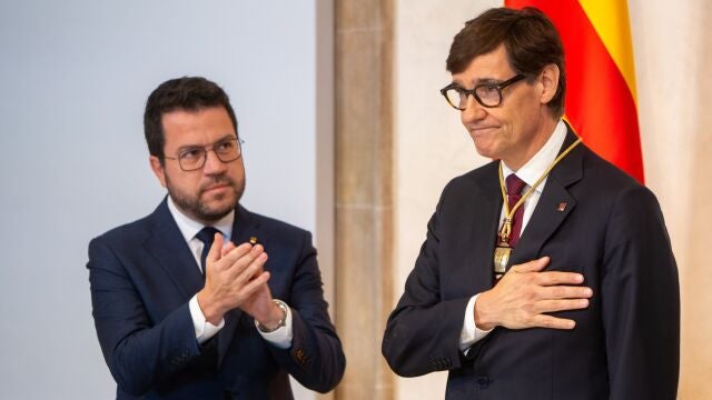 El expresident de la Generalitat, Pere Aragonès (i) y el nuevo president de la Generalitat de Cataluña, Salvador Illa (d), durante la toma de posesión de Salvador Illa como president de la Generalitat, en el Palau de la Generalitat