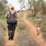 Un cazador en el campo con un perro