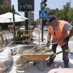 Un trabajador de la construcción junto a un termómetro que marca cuarenta grados en la avenida de la Fama de Murcia.