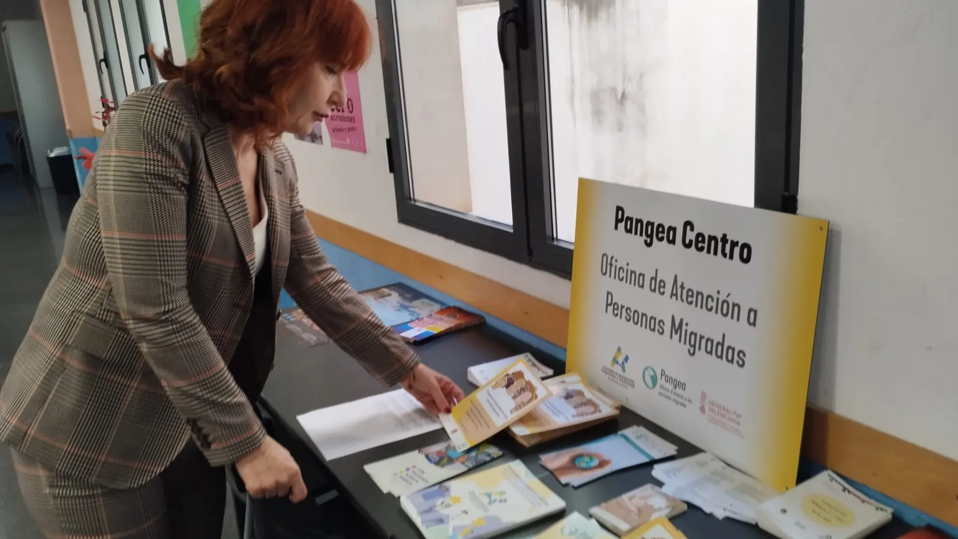 Un señora consulta los folletos facilitados por la Oficina de Atención a Personas Migradas PANGEA, un servicio de la Concejalía de Derechos Públicos del Ayuntamiento de Alicante