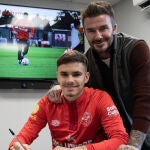 David junto a su hijo, durante la firma del contrato