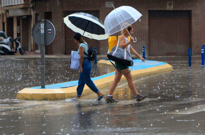 Imagen de dos mujeres bajo la lluvia y el granizo