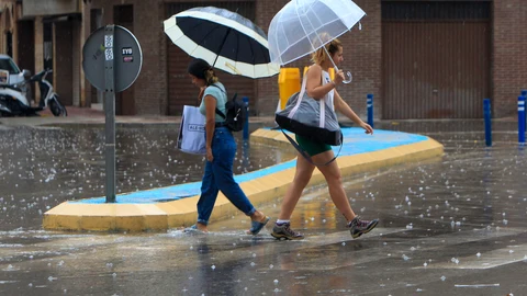 Imagen de dos mujeres bajo la lluvia y el granizo