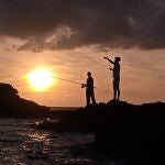 Pescadores con caña en una orilla