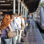 Un grupo de pasajeros espera a un convoy en una terminal. 