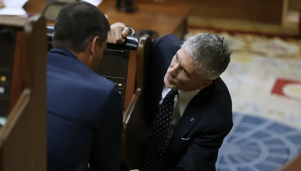 El ministro del Interior, Fernando Grande-Marlaska, se acerca al escaño del presidente del Gobierno, Pedro Sánchez
