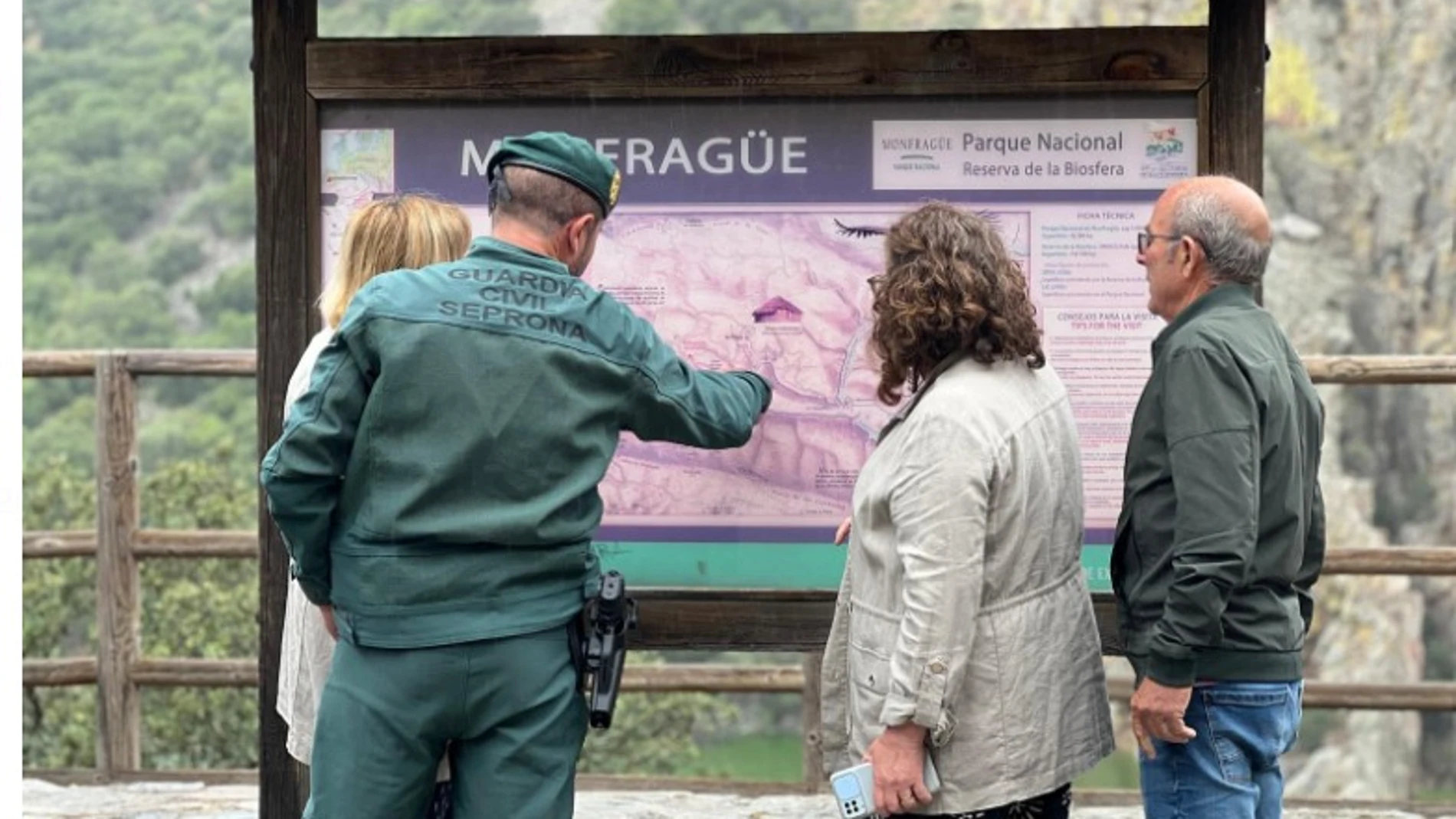 Un agente realiza indicaciones a visitantes del parque